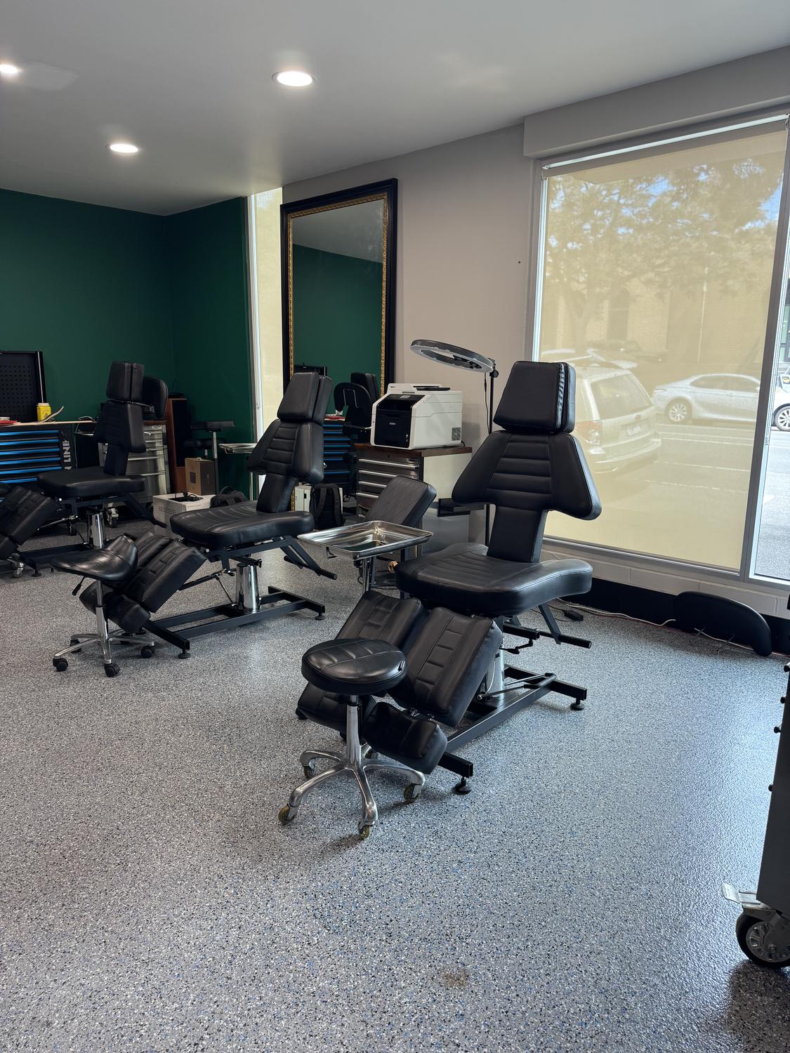 The studio floor at Mother Goose Tattoo — tattoo chairs against the green wall